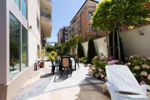 a patio with chairs and tables in a building at Zevs Residence in Nesebar