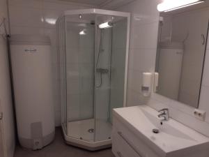 a bathroom with a shower and a sink and a mirror at Skudenes Camping in Skudeneshavn