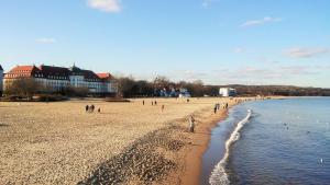 a group of people on a beach with the water at Apartament Anny in Sopot