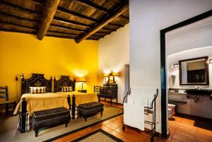 a bedroom with a bed and a yellow wall at Quinta Da Espada in Évora
