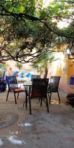 a group of chairs and a table under a tree at Casa Antica a 10 metri dalla Spiaggia con giardino interno in Porto Recanati