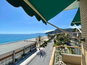 - un balcon avec un parasol offrant une vue sur la plage dans l'établissement Hotel Boncardo, à Finale Ligure