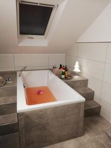 a bath tub with a book in it in a bathroom at Emmerich s neu errichtete DG-Wohnung in Bad Wildungen