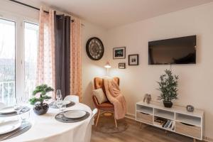 a living room with a table and a tv at T2 proche Disneyland Paris in Meaux