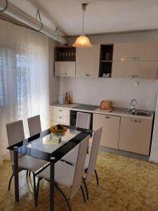 a kitchen with a dining room table and chairs at Harbour in Brgulje