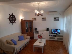 a living room with a couch and a tv at Harbour in Brgulje