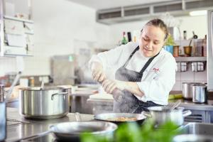 een chef-kok die eten bereidt in een keuken bij Reck's Hotel-Restaurant in Salem