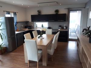 a kitchen and dining room with a wooden table and chairs at Ferienhaus Josef in Alsóörs