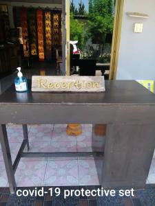 une table avec un signe d'immatriculation au-dessus de celle-ci dans l'établissement Huan Amphan, à Chiang Rai