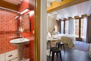 łazienka z umywalką i łóżkiem w pokoju w obiekcie La Casa De Santa María ESTUDIOS w mieście Vitoria-Gasteiz