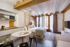 pokój hotelowy z dwoma łóżkami i stołem w obiekcie La Casa De Santa María ESTUDIOS w mieście Vitoria-Gasteiz