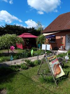 ein Schild im Gras im Garten in der Unterkunft Zimmer und Apartment Rosi in Krakow am See