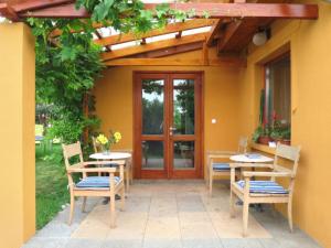a patio with tables and chairs in front of a building at Ferienhaus Magyar in Lovas