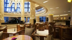 a restaurant with wooden tables and chairs and a chandelier at Kempinski Hotel Taiyuan in Taiyuan