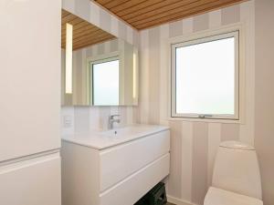 ein Bad mit einem Waschbecken, einem WC und einem Fenster in der Unterkunft 8 person holiday home in Tranek r in Tranekær