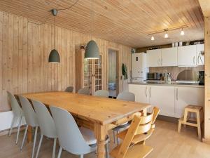 eine Küche und ein Esszimmer mit einem Holztisch und Stühlen in der Unterkunft 8 person holiday home in Tranek r in Tranekær