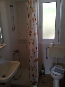 a bathroom with a shower curtain and a sink at Nicolas Rooms in Fiskardo