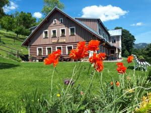 a house with red flowers in front of it at U Novotných in Špindlerův Mlýn