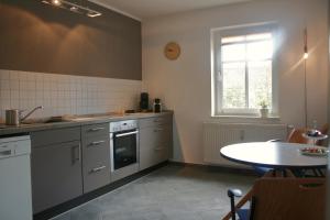 a kitchen with a table and a sink and a stove at FEWO am Markt in Neustadt in Sachsen