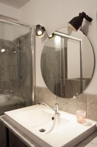 bagno con lavandino e specchio di Central Apartment with boulevard view a Niš