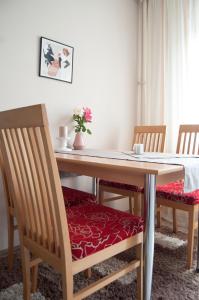 tavolo da pranzo con 2 sedie e cuscino rosso di Central Apartment with boulevard view a Niš