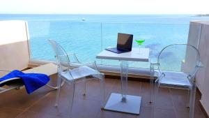 a table and chairs with a laptop computer on it at Erytha Hotel & Resort Chios in Karfas