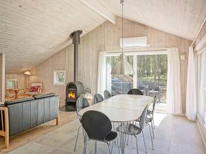 comedor con mesa, sillas y chimenea en Four-Bedroom Holiday home in Nexø 14, en Spidsegård