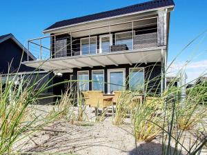 a house on the beach with tall grass at 6 person holiday home in Hemmet in Hemmet