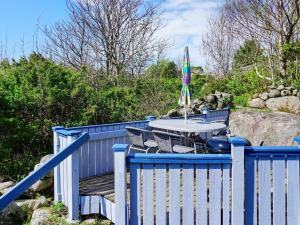 a blue fence with a table and an umbrella at 4 person holiday home in HAMBURGSUND in Hamburgsund