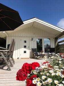 eine Terrasse mit roten und weißen Blumen vor einem Haus in der Unterkunft Lyckhus in Ljungskile