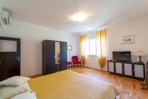 1 dormitorio con 1 cama y TV de pantalla plana en Apartments Naja, en Split