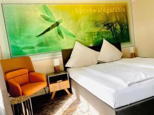 1 dormitorio con 1 cama y 1 silla naranja en Spree - Waldhotel Cottbus en Cottbus