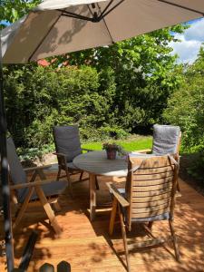 einen Tisch und Stühle unter einem Sonnenschirm auf einer Terrasse in der Unterkunft FeWo Nelly Marie Wohnung Nelly in Hademstorf