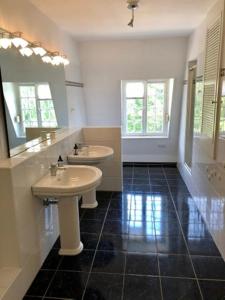 a bathroom with two sinks and a mirror at Villa Erbschloe in Remscheid