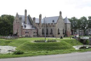 a large building with a grassy yard in front of it at B&B Kleine Vliet in Medemblik