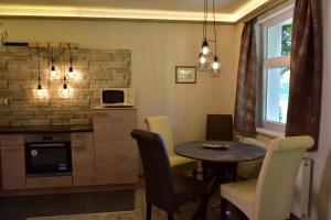 a kitchen with a table and chairs and a microwave at Villa Therme Hévíz in Hévíz