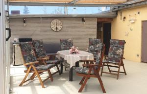 a patio with a table and chairs and a clock at Haus Anke in Brandenburg an der Havel