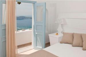 a bedroom with a bed and a view of the ocean at Casa Florina in Imerovigli