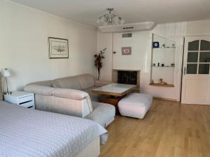 a living room with a bed and a couch at Baltas apartamentas in Juodkrantė