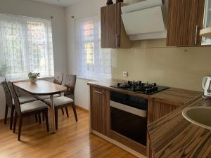 a kitchen with a table and a stove top oven at Baltas apartamentas in Juodkrantė