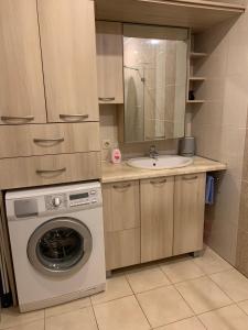 een kleine keuken met een wasmachine en een wastafel bij Baltas apartamentas in Juodkrantė