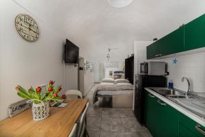 uma cozinha com armários verdes e um balcão com flores em La Magnolia, Caressa de mä em Bordighera