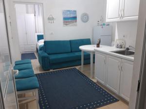 a kitchen with a blue couch and a table at Blue Coral apartament in Velipojë
