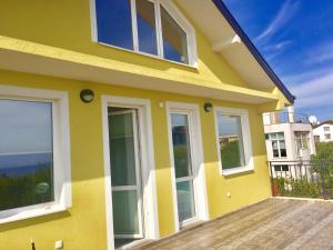 een geel huis met ramen op een houten terras bij Luxury House In Chervenka next to Gradina beach in Chernomorets