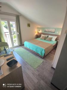 een slaapkamer met een bed en een bureau en een kamer met een bed bij Apartment The Sea Coast in Kotor