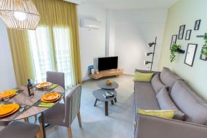 ein Wohnzimmer mit einem Sofa und einem Tisch in der Unterkunft Suites 05-06 - Smart Cozy Suites - Large 2 bedroom, near Athens and metro in Athen