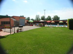 einen Garten mit Stühlen und Sonnenschirmen sowie einem Pool in der Unterkunft VILLA MARIA in Altopascio