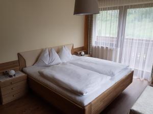 a bed with white sheets and pillows in a bedroom at Lackenhof in Rauris