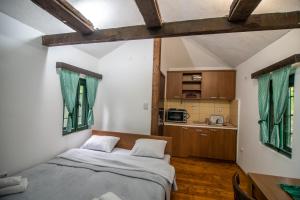Lodge Morava في Vrnjačka Banja: غرفة نوم بسرير كبير ومطبخ