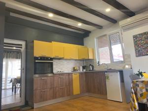 a kitchen with wooden cabinets and yellow appliances at Trakia Street Apartment in Plovdiv